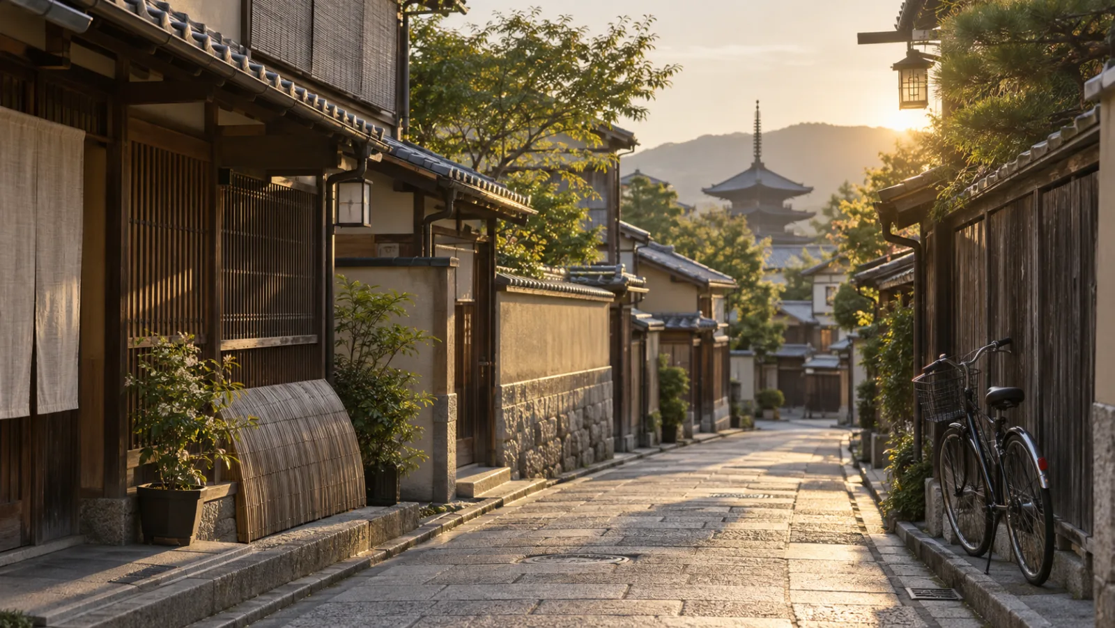 朝の京都の住宅地の路地。木の格子の町家が並び、壁に自転車が立てかけてある